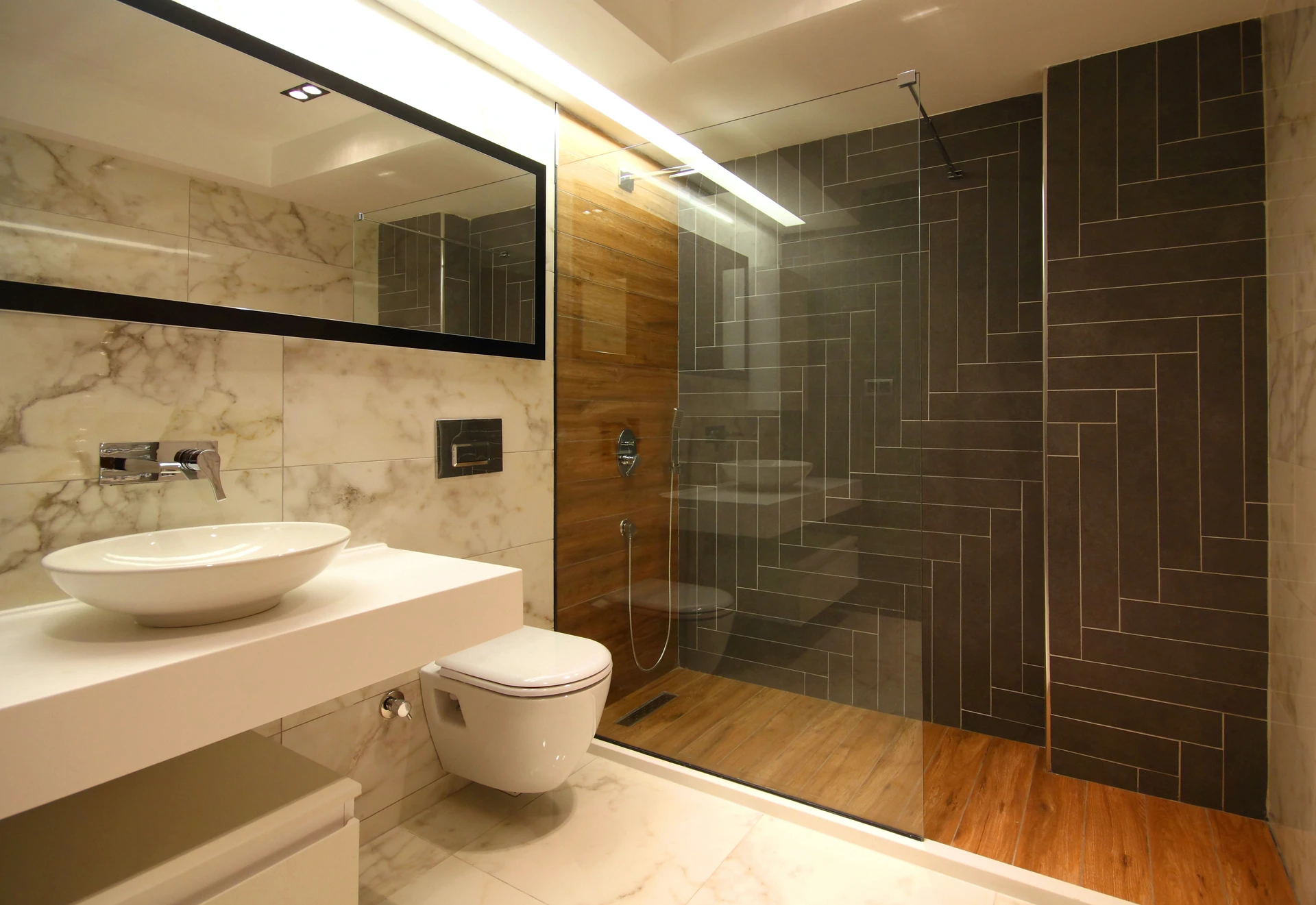 Salle de bain moderne haut de gamme avec douche à l'italienne vitrée, carrelage anthracite grand format à joints fins
