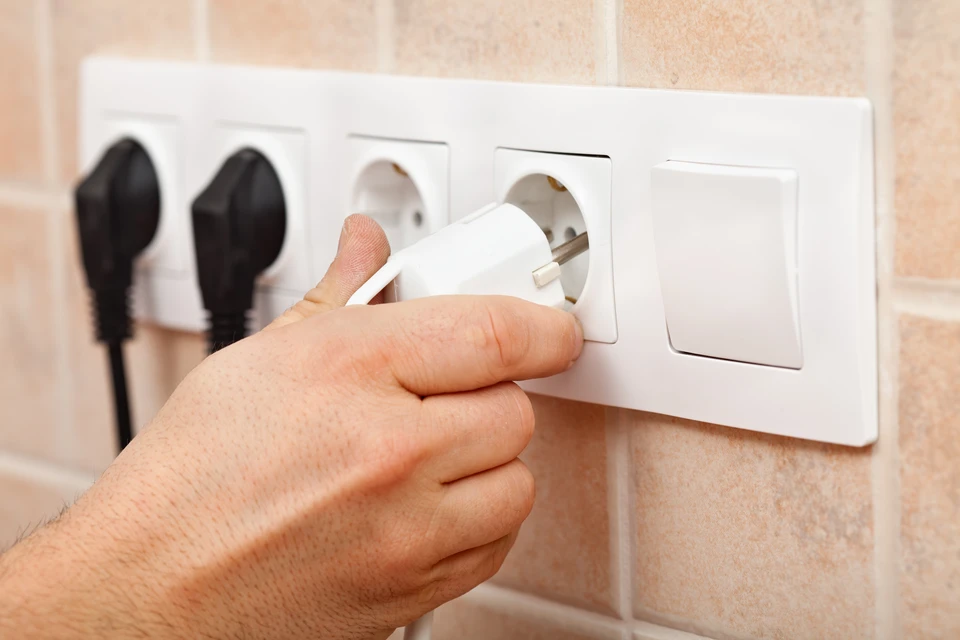Main intérieure avec prise électrique murale blanche à quatre alvéoles