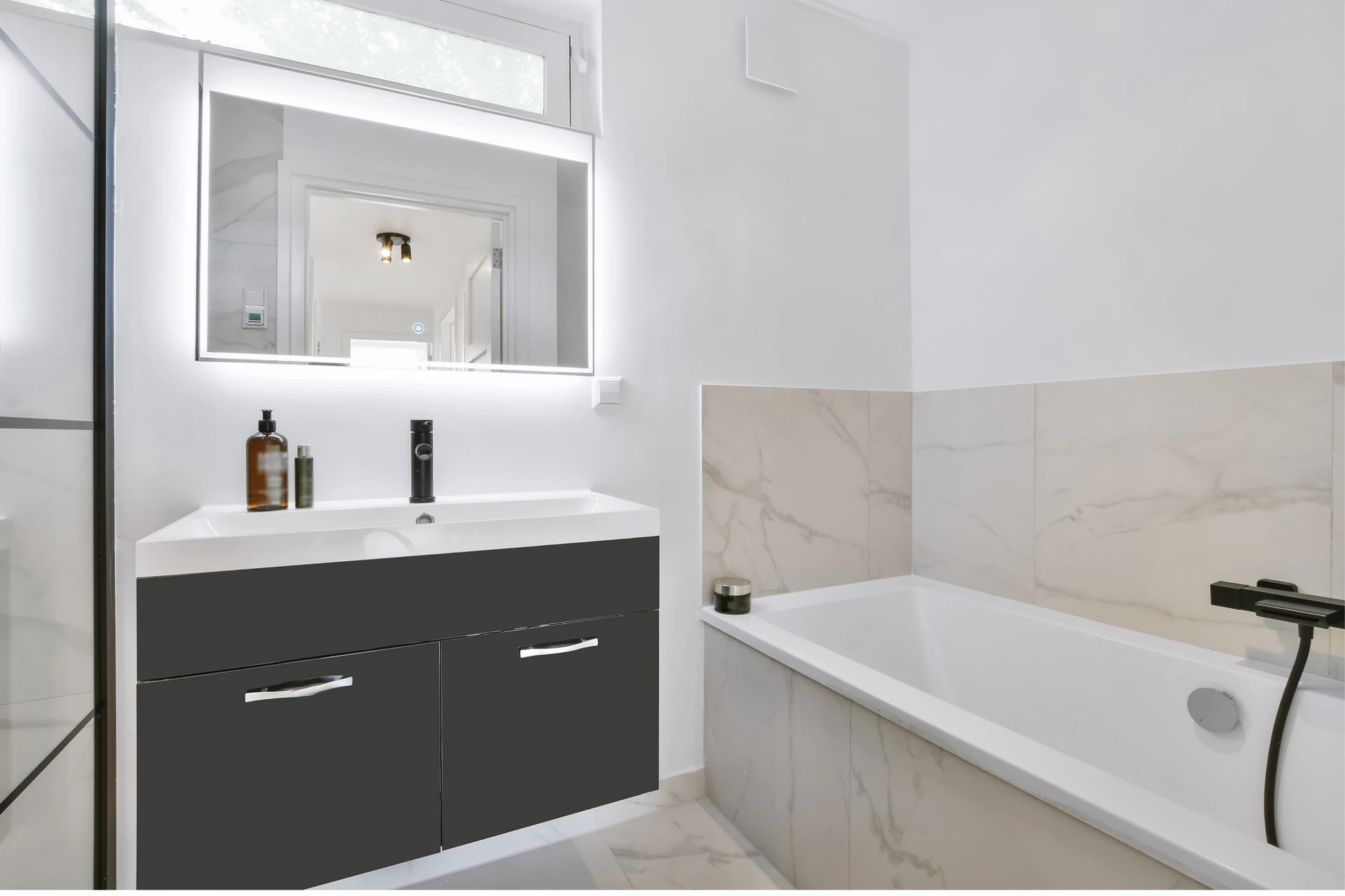 Salle de bain moderne avec baignoire encastrée, meuble vasque suspendu anthracite à deux tiroirs, miroir LED rectangulaire