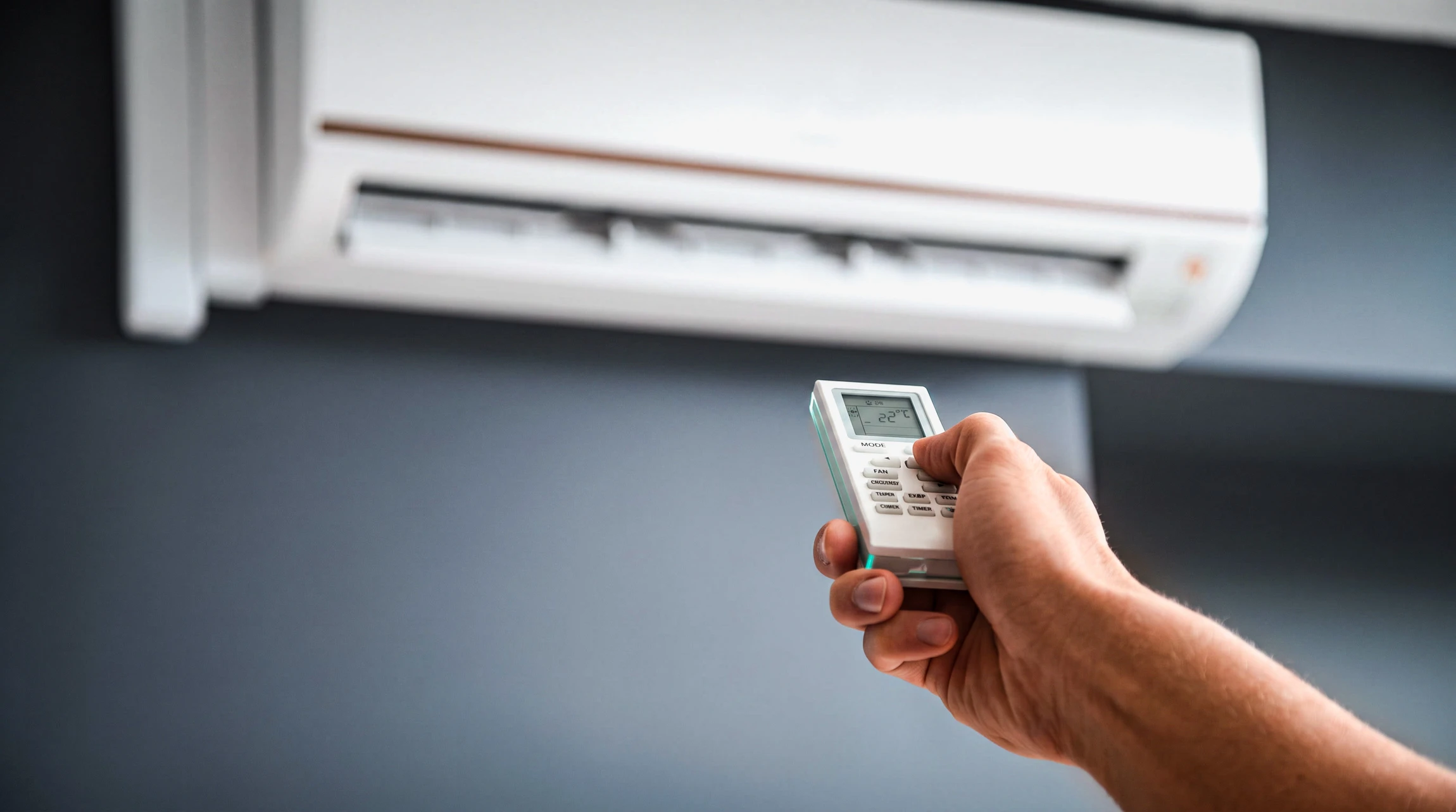 Scène extérieure sur mur orange avec unité extérieure de climatisation fixée sur support métallique